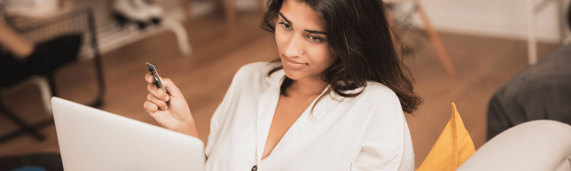 Imagem de uma mulher segurando um cartão de crédito